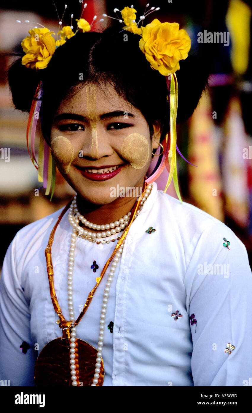 Giovane donna a Pwe festival religioso si prepara a ballare la parte di un "Nat la moglie' indossa i fiori nei capelli e tanaka sul suo viso Foto Stock