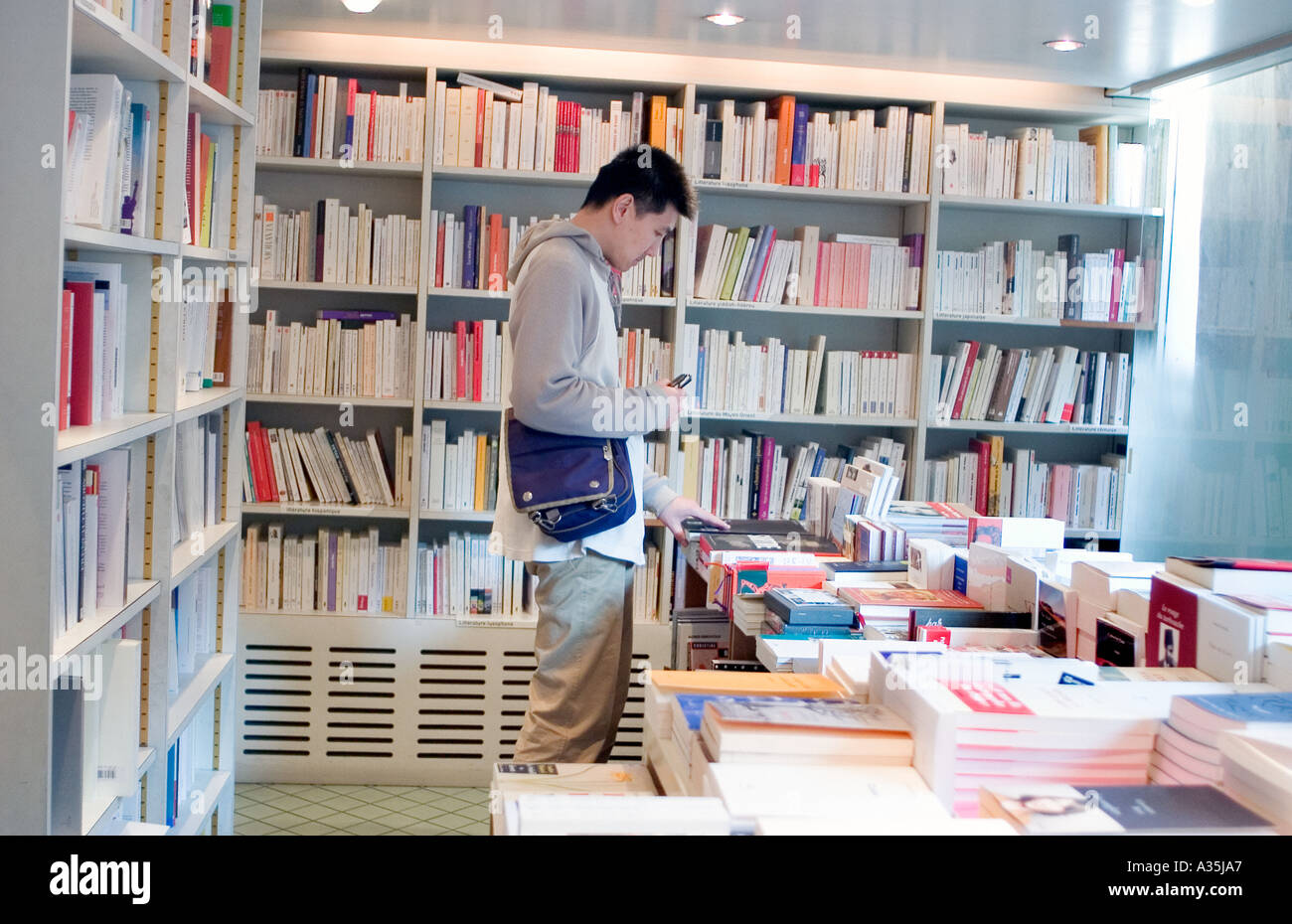 Parigi France Man Shopping Education Stores 'la Hune Bookstore' giovani Asian Man (negozio chiuso) studente Francia Foto Stock