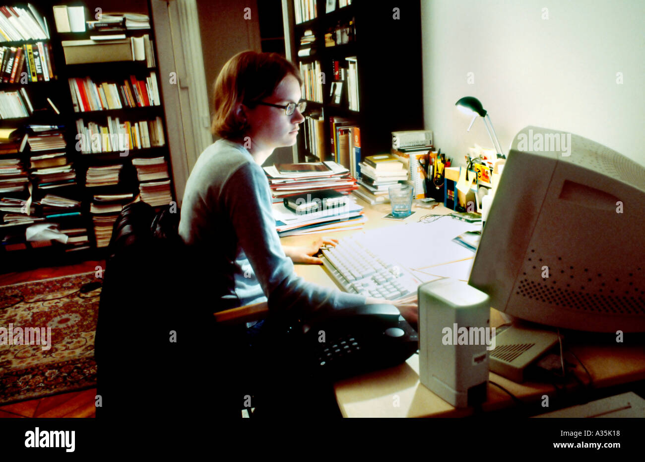 Parigi, Francia, giovane donna adulta, lavora fino a tardi sul computer in ufficio in casa occupato scrivania Foto Stock