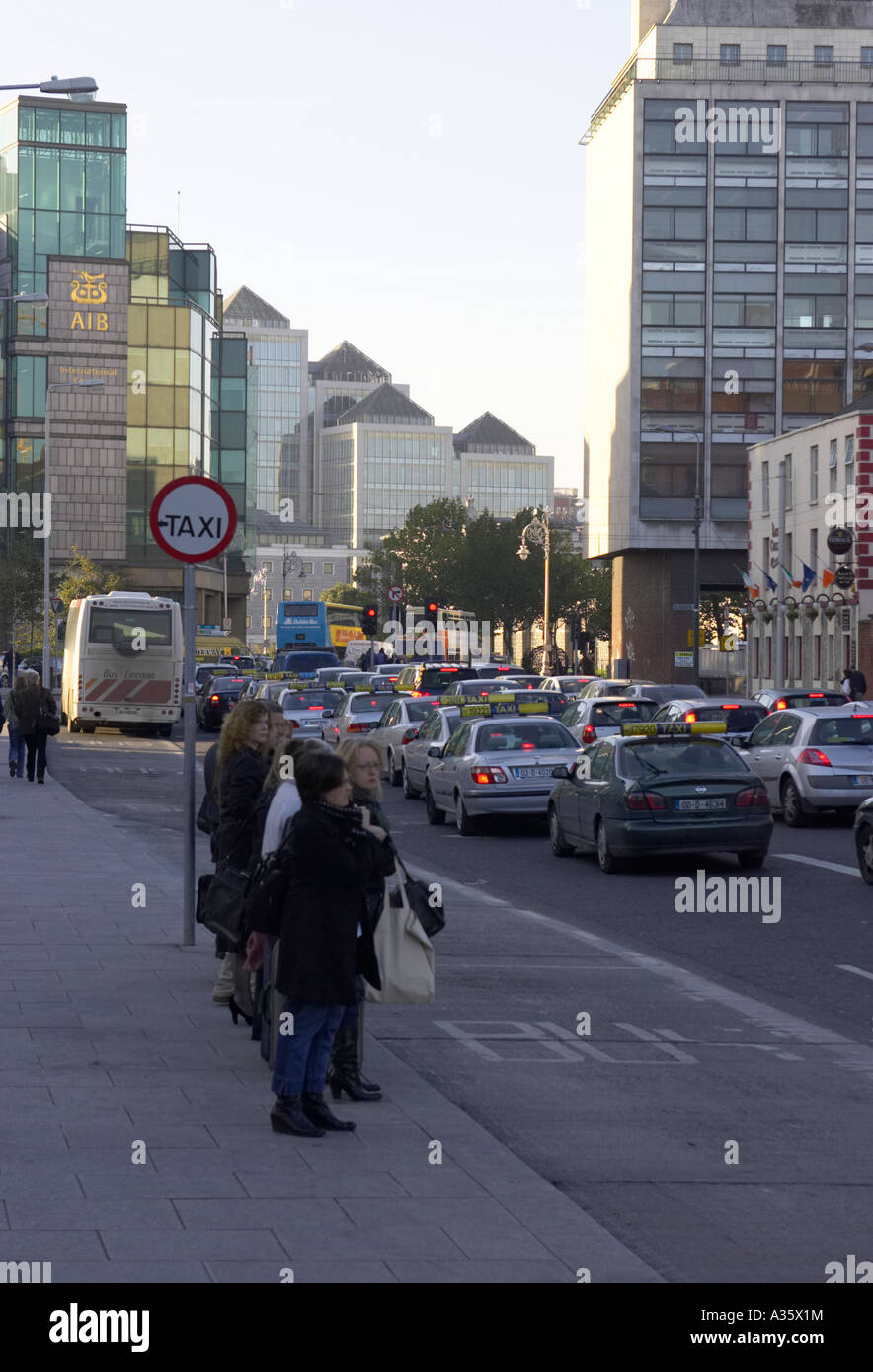 Linea ordinata fila di persone in un taxi in piedi sul sentiero dal lato di una strada Foto Stock