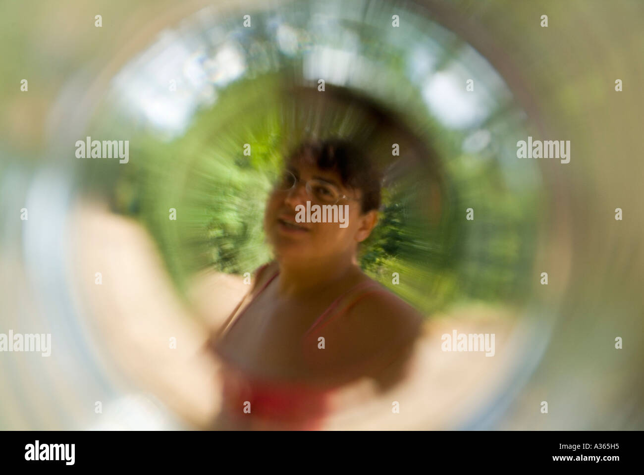 Donna matura osservata attraverso un fondo di un vetro Foto Stock