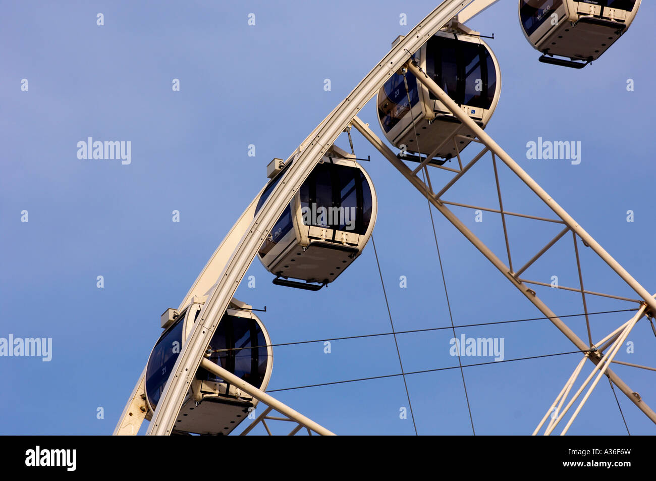 Capsule passeggeri su una ruota panoramica vista contro un cielo blu. Foto Stock