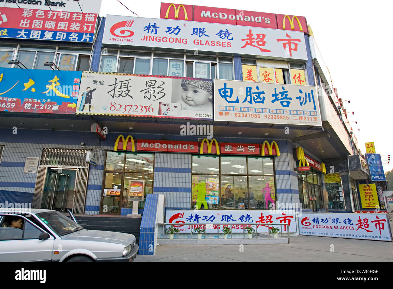 Cina Pechino giovane professionista urbano giovane cinese di lasciare il McDonalds fast food in franchising nel loro fine del modello di vettura Foto Stock