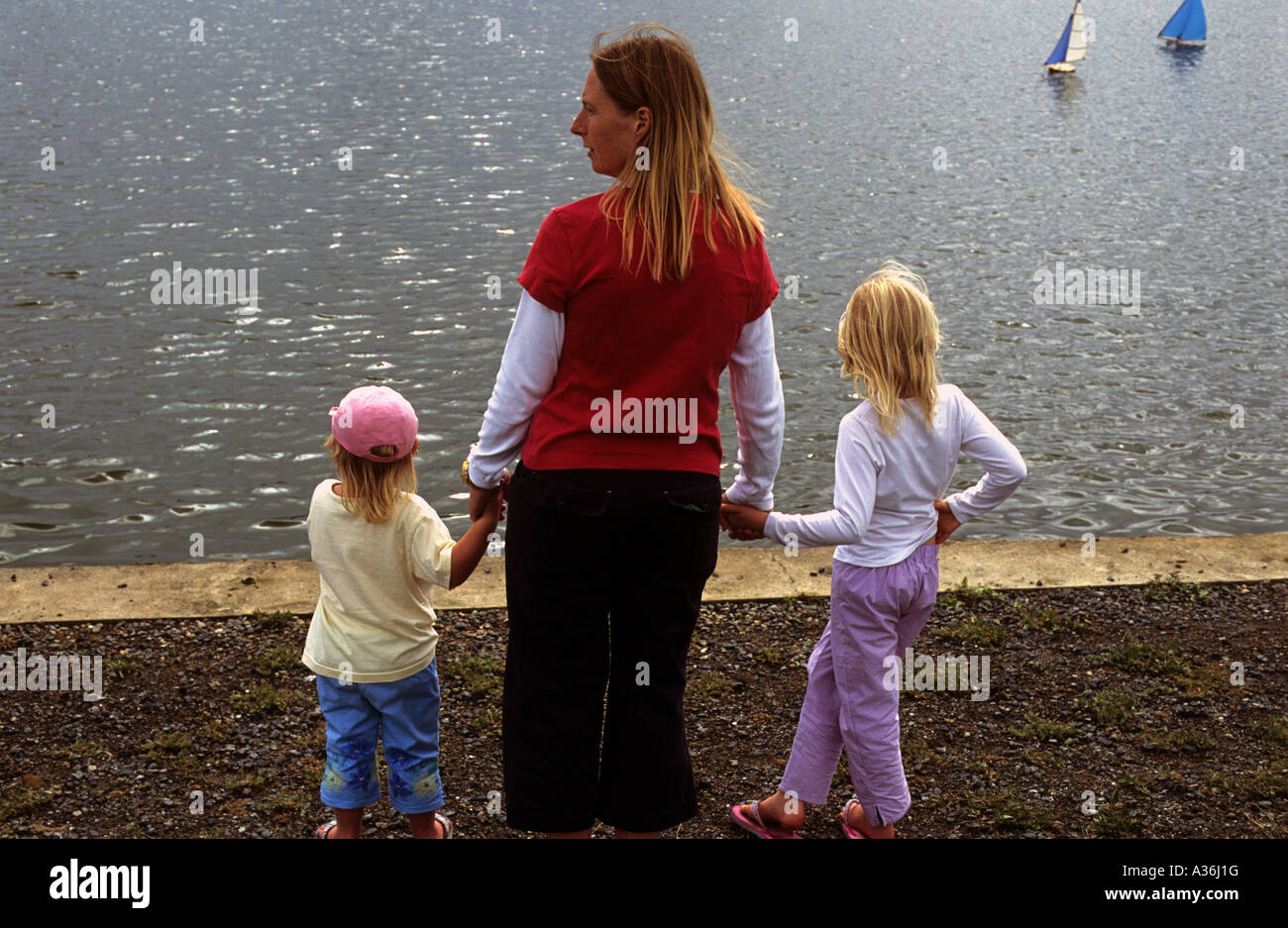 Donna con bambini accanto a un modello di yacht pound, Southwold, Suffolk, Regno Unito. Foto Stock