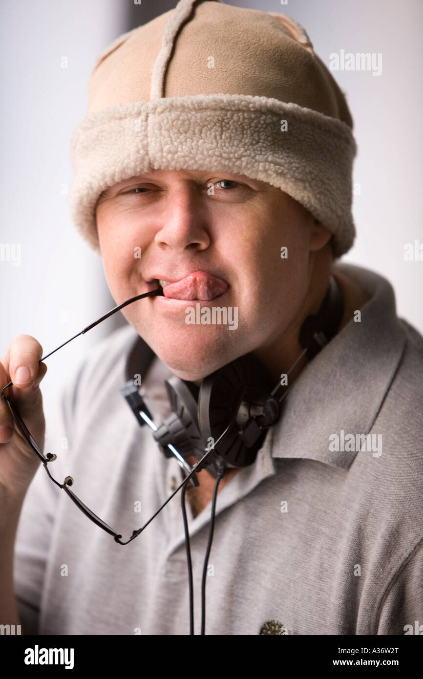 Fumetto ritratto di un giovane uomo in un cappello di pelliccia fuori la sua lingua con i telefoni di testa intorno al suo collo Foto Stock