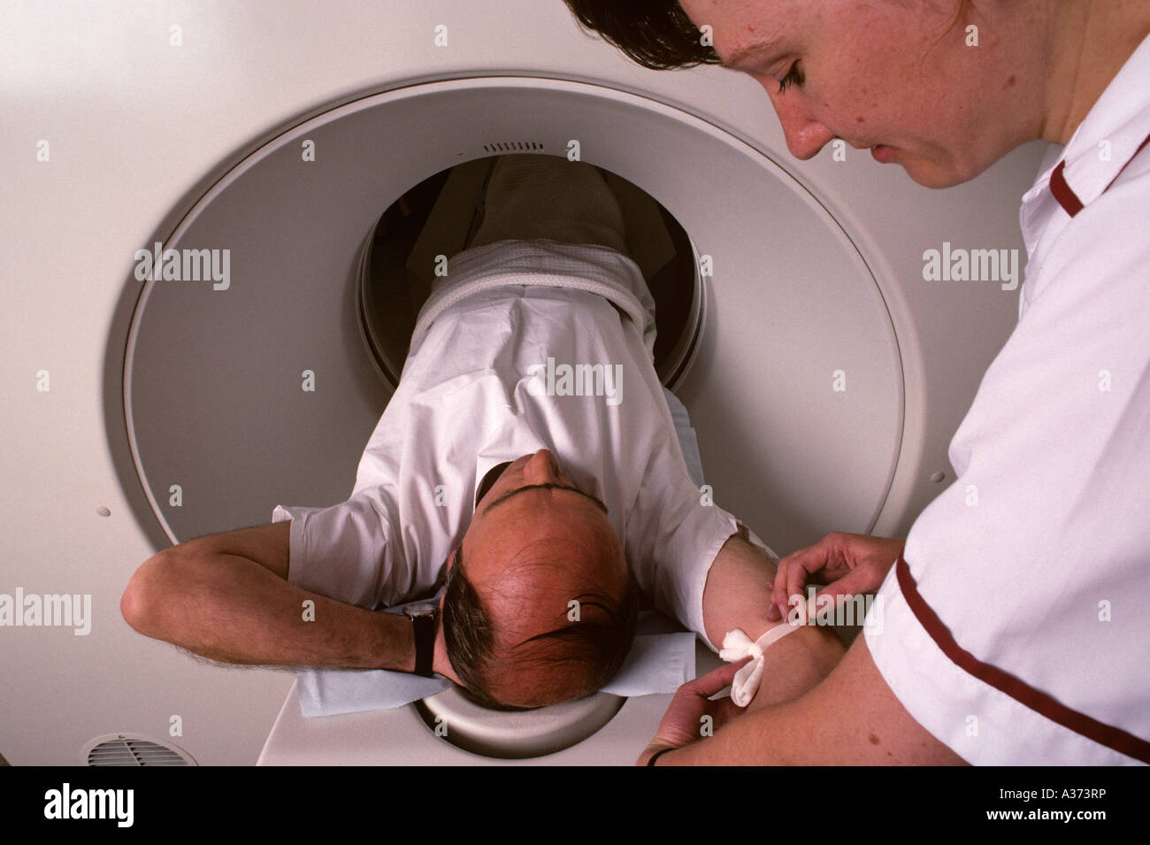 I colloqui di infermiere paziente inserendo uno scanner MRI in un ospedale di Londra, Regno Unito Foto Stock