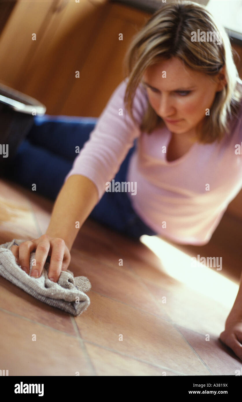 La donna la lucidatura di un pavimento di piastrelle Foto Stock