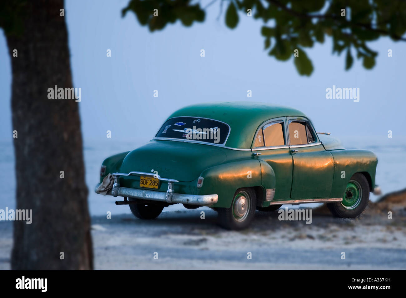 Un antico auto Chevrolet si trova lungo la spiaggia di Playa Ancon, una spiaggia cittadina vicino a Trinidad Foto Stock