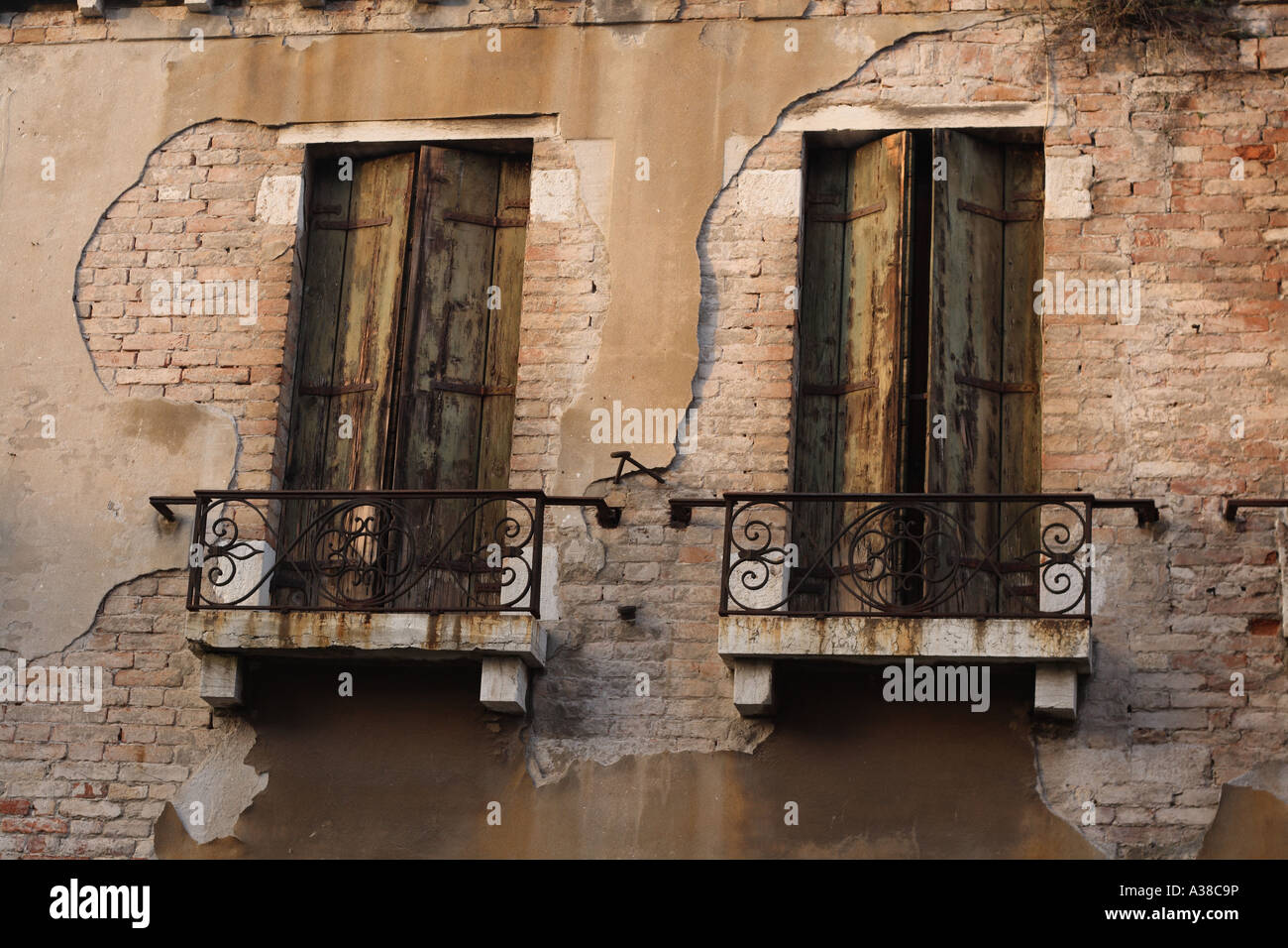 Finestre con balconi sul lato di una casa a Venezia Italia mostra erosione da acqua salata e vento Foto Stock