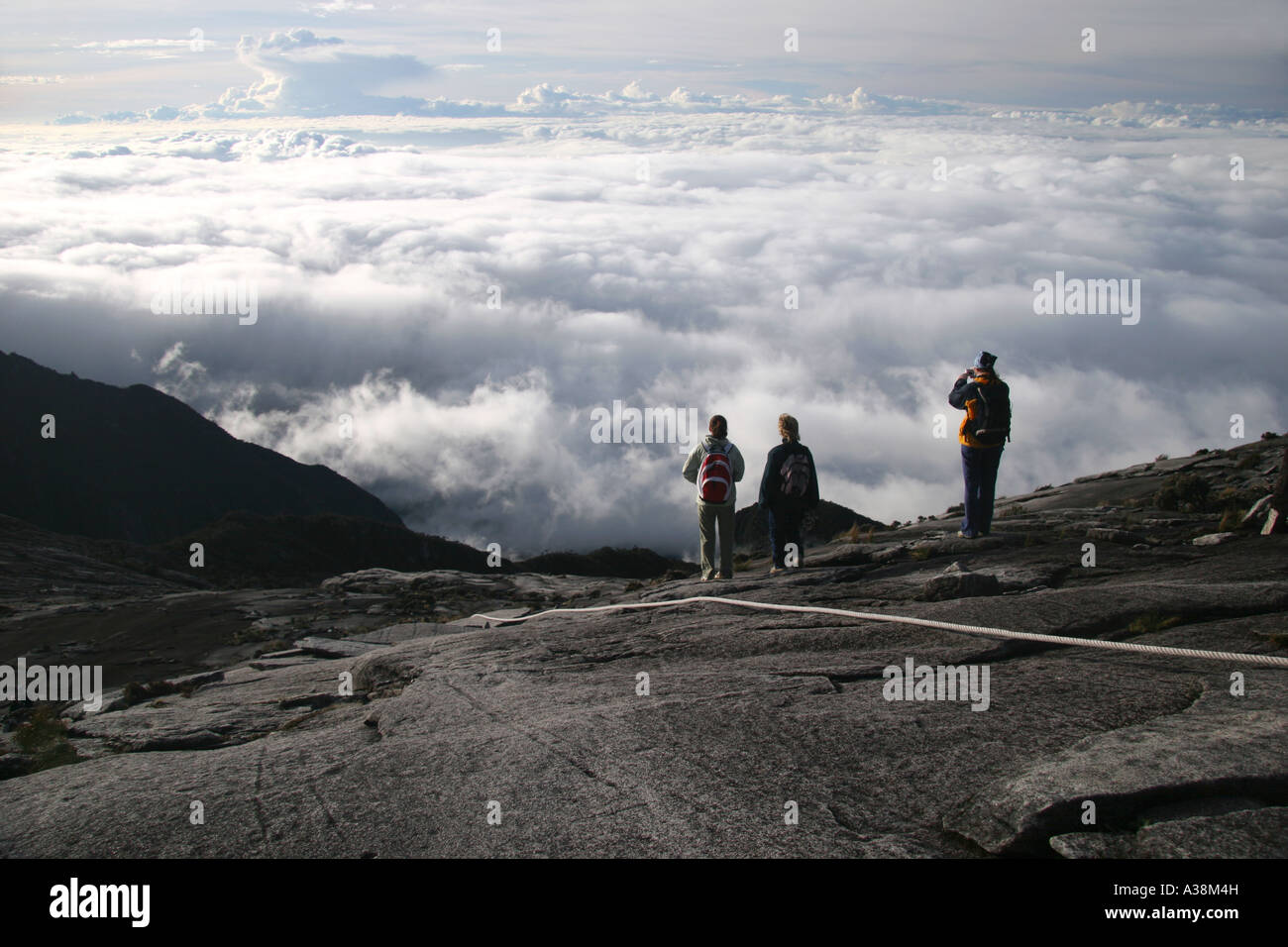 Gli escursionisti guardare le nuvole roll-in su la loro discesa di Mt Kinabalu, a 4095m i più alti in Asia SE. Sabah, Borneo Malaysia Foto Stock