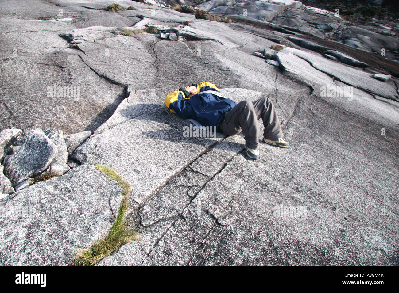 Esaurito escursionista prendendo un riposo sulla sua salita del Mt Kinabalu, a 4095m i più alti in Asia SE. Sabah, Borneo Malaysia Foto Stock