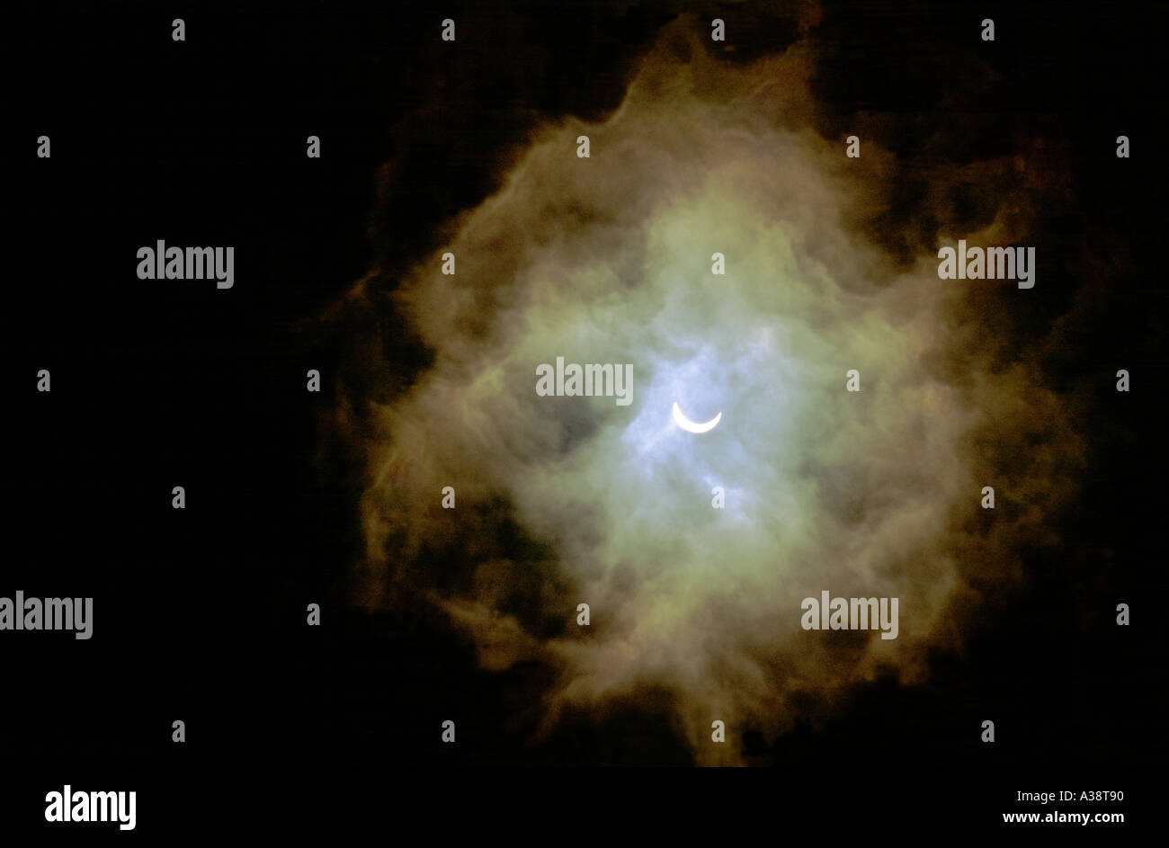 Eclissi solare. Luna passa davanti al sole quasi pieno di eclipse. Atmosfera romantica velata da sottili tempestoso cloud di compensazione Foto Stock