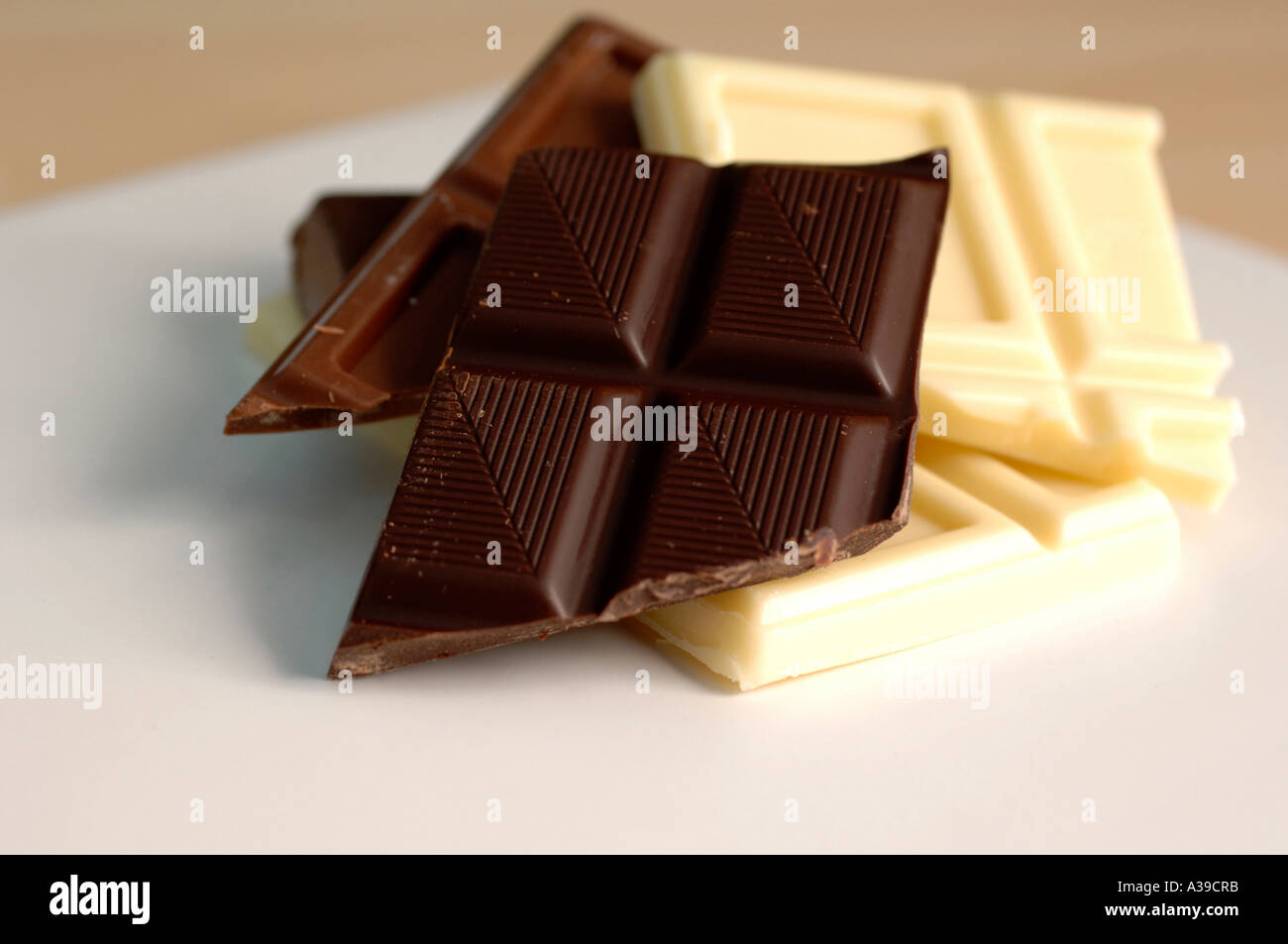 White cioccolato fondente e al latte pezzi su una piastra bianca Foto Stock