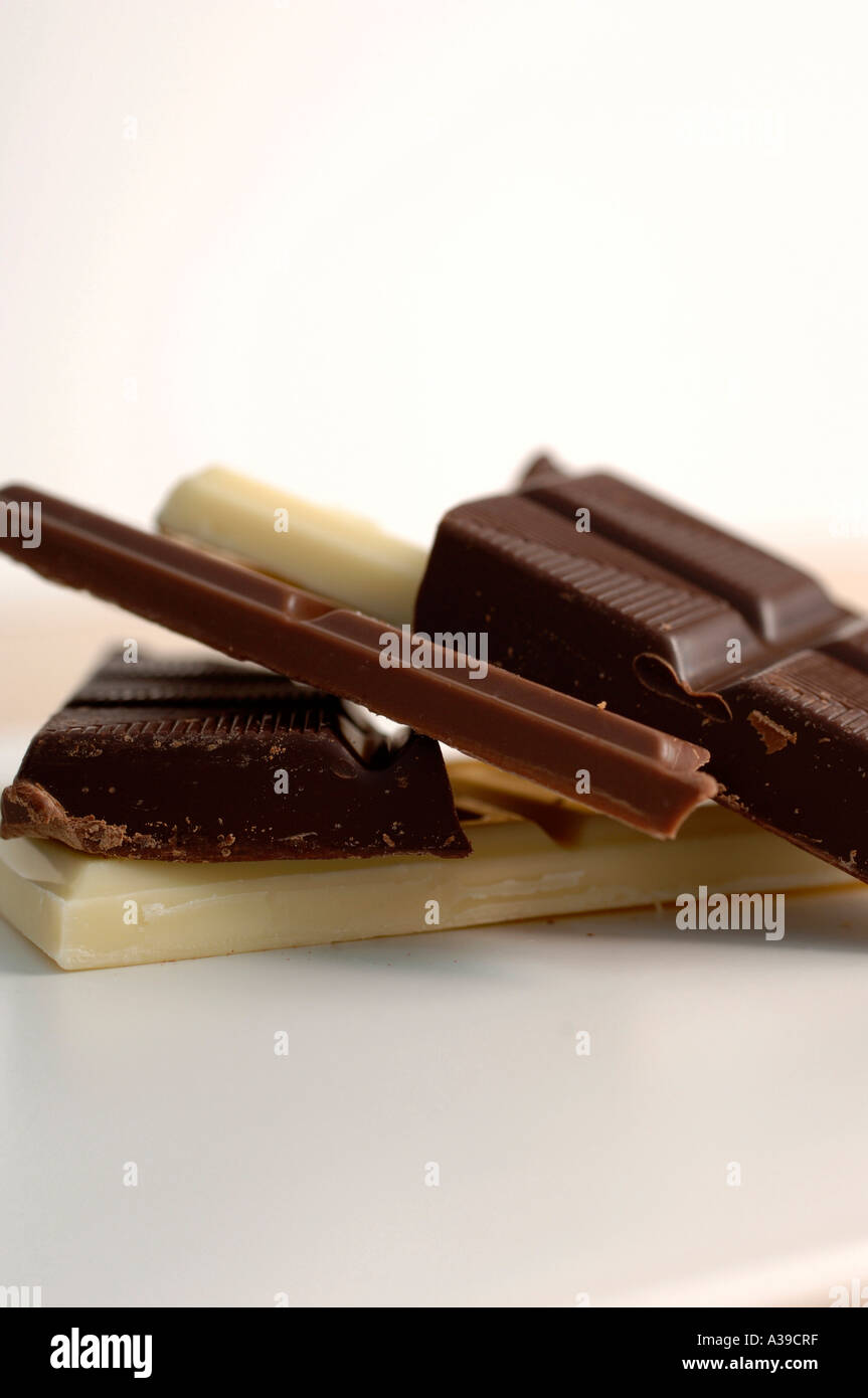 White cioccolato fondente e al latte pezzi su una piastra bianca Foto Stock
