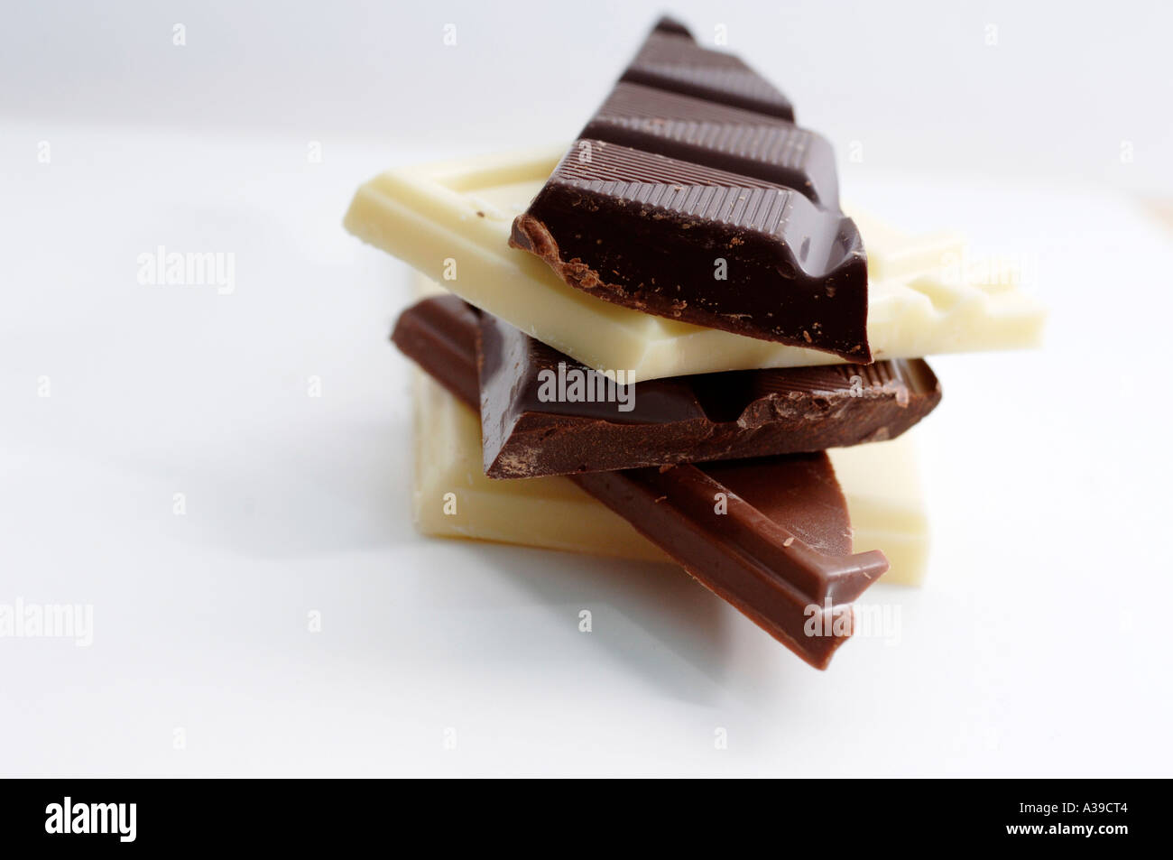 White cioccolato fondente e al latte pezzi su una piastra bianca Foto Stock