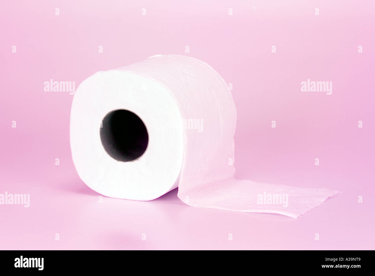 Loo bianco rotolo di carta igienica carta su sfondo rosa Foto Stock