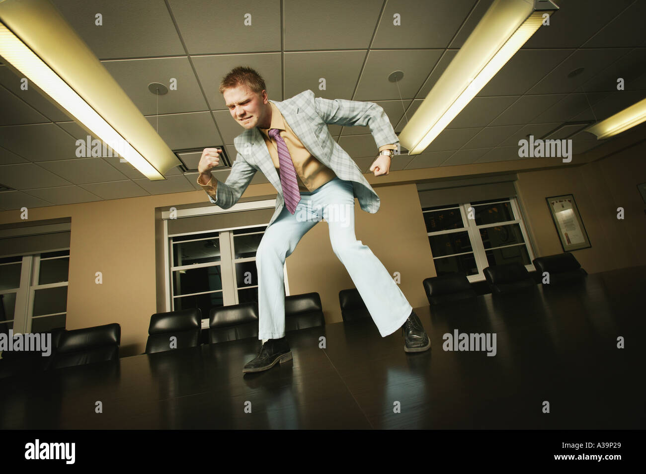 I m. L'uomo ballando sul tavolo della sala riunioni Foto Stock