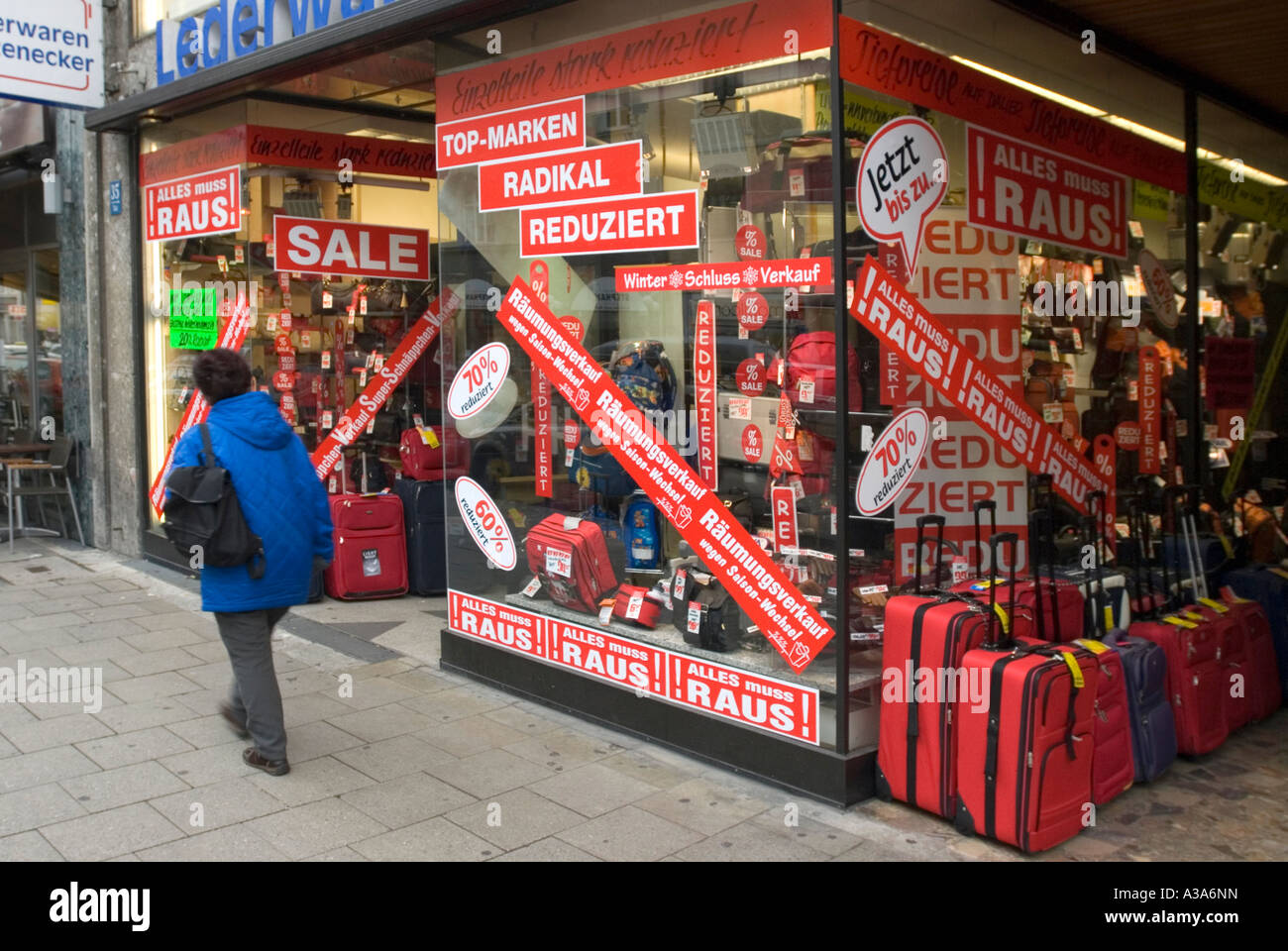 Donna sul marciapiede passando da un negozio con sconto invernale vendita Monaco di Baviera Baviera Germania Foto Stock