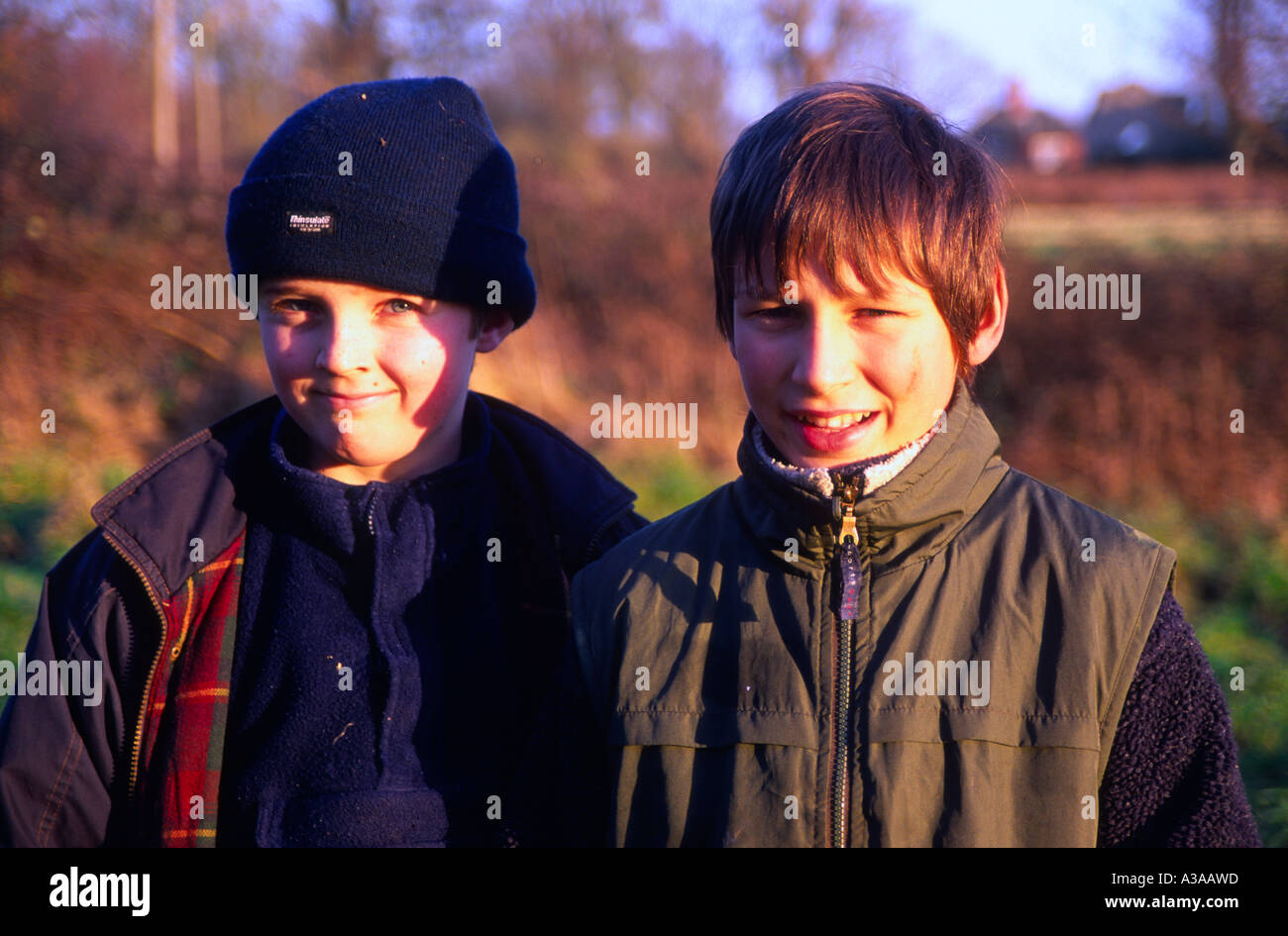 Due dodici anni - old boys in piedi spalla a spalla in posa all'aperto in inverno Foto Stock