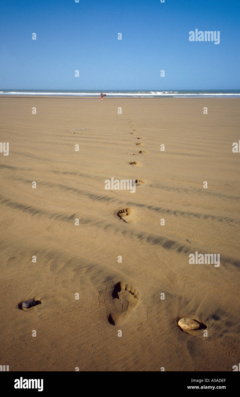 Surfer in esecuzione nel mare di Cap Sim Beach Marocco Foto Stock