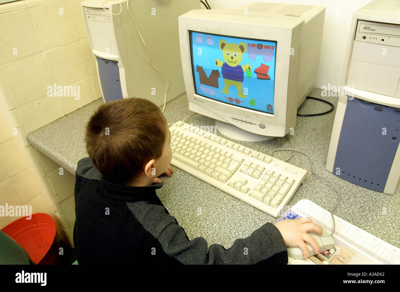 La scuola materna di bambini che giocano su computer Foto Stock