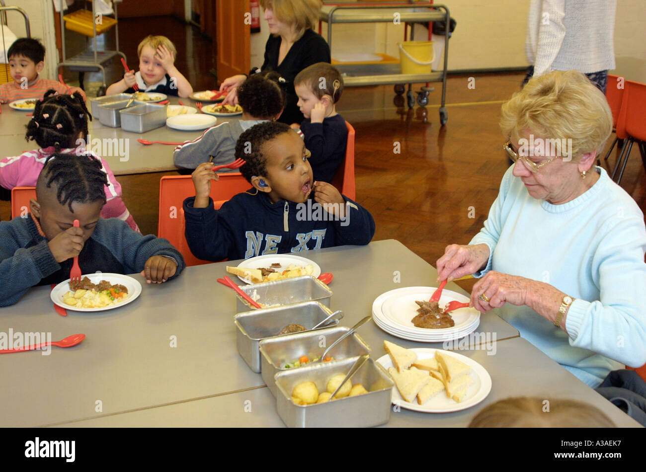 Bambini della scuola materna di mangiare pasto cucinato in caffetteria Foto Stock