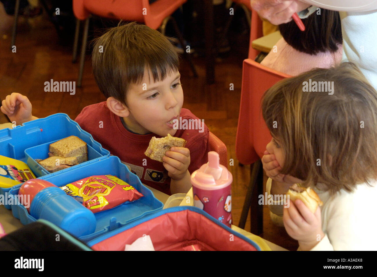Bambini della scuola materna di mangiare il pranzo al sacco in caffetteria Foto Stock