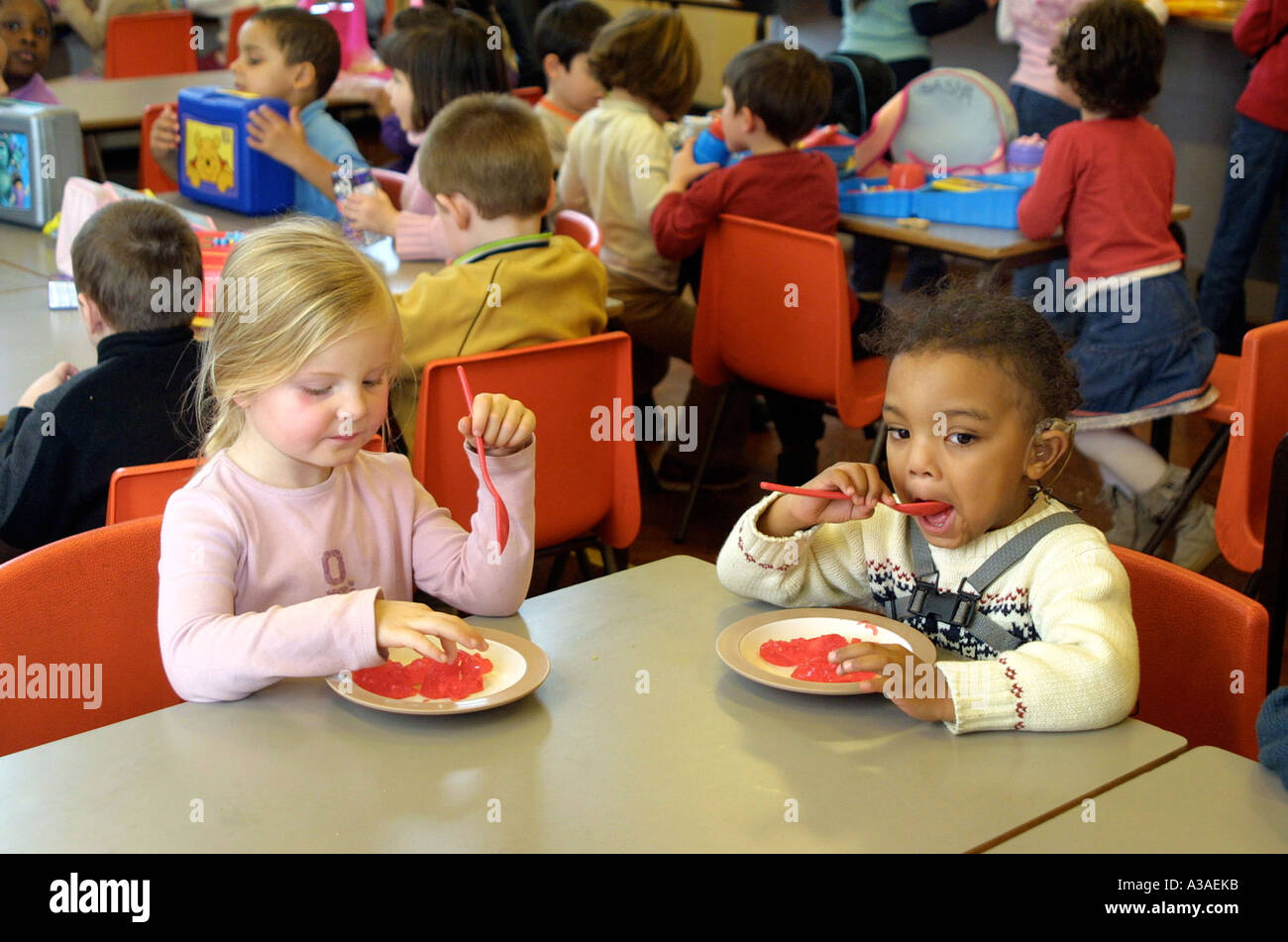 La scuola materna di ragazze mangiare Jelly per ora di pranzo dessert Foto Stock