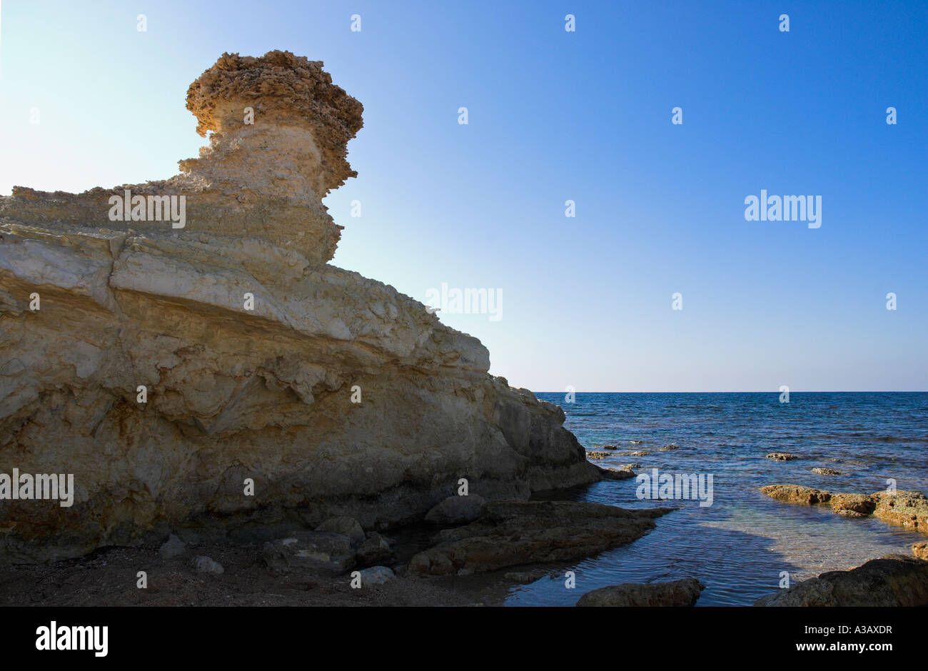 Vento mediterraneo e WAVE eroso erosione mare pila contro un cielo blu. Foto Stock