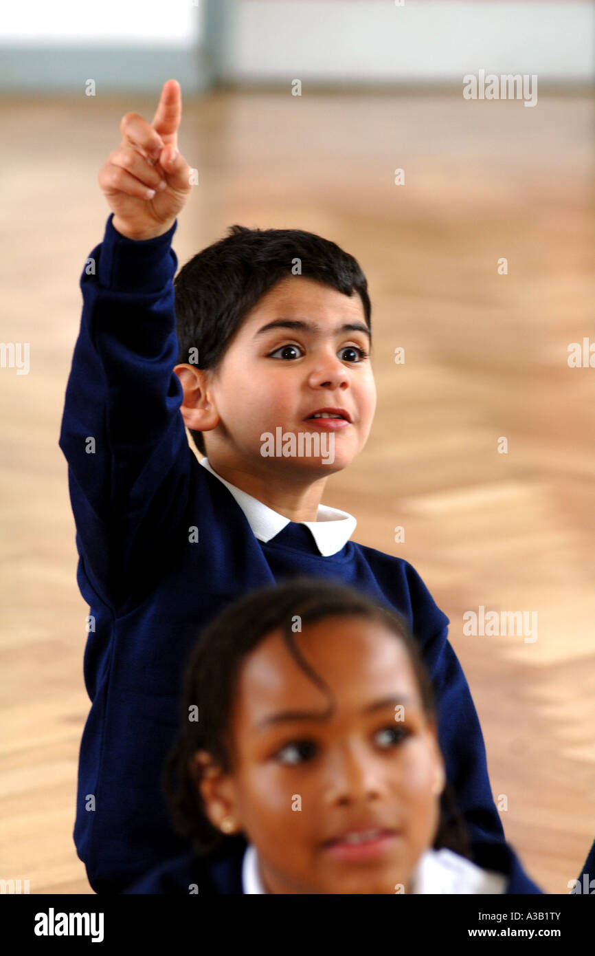 Gruppo misto di bambini della scuola primaria si uniscono in una discussione di gruppo con il maestro West Yorkshire Foto Stock