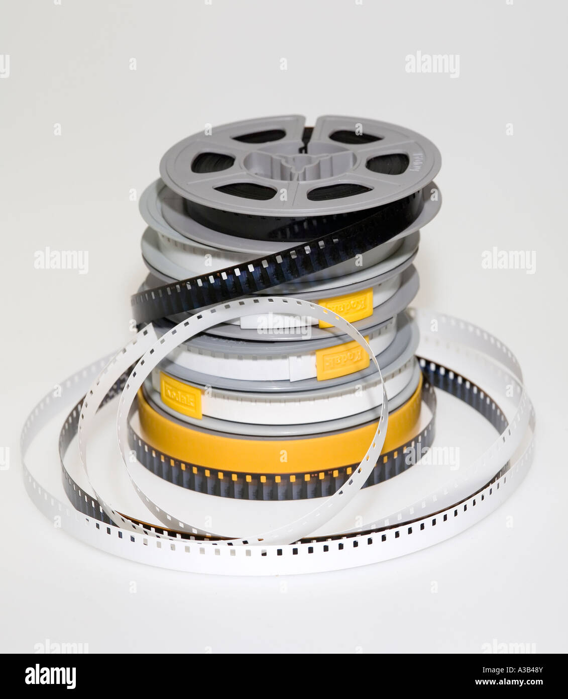 Pila di dilettante 8mm cine bobine di pellicola con una bobina in svolgimento a mostrare il film e leader Foto Stock