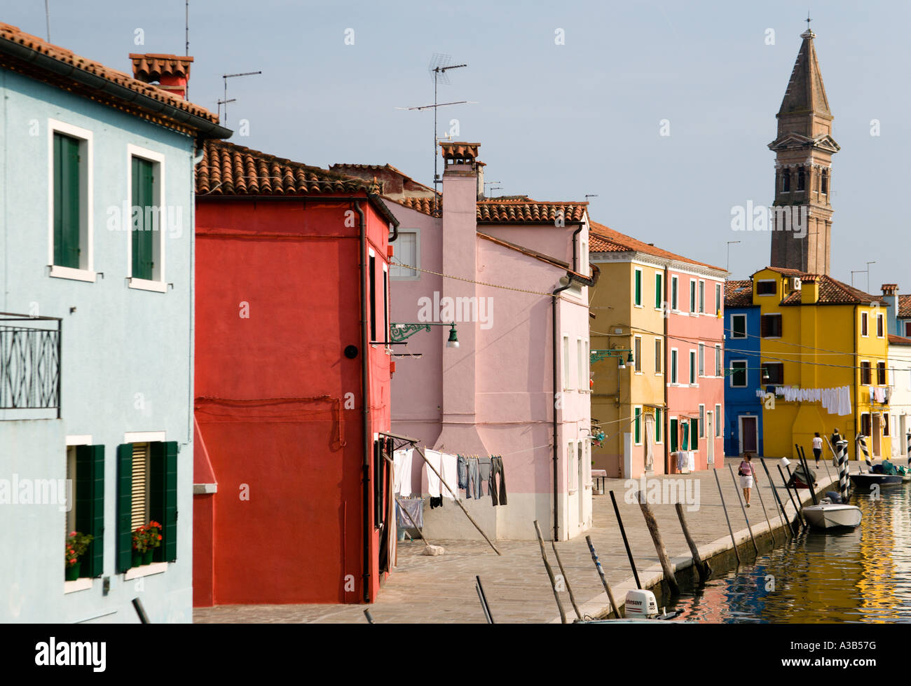Italia Veneto Laguna di Venezia Isola di Burano case colorate accanto a un canale con la torre della chiesa di San Martino a distanza Foto Stock