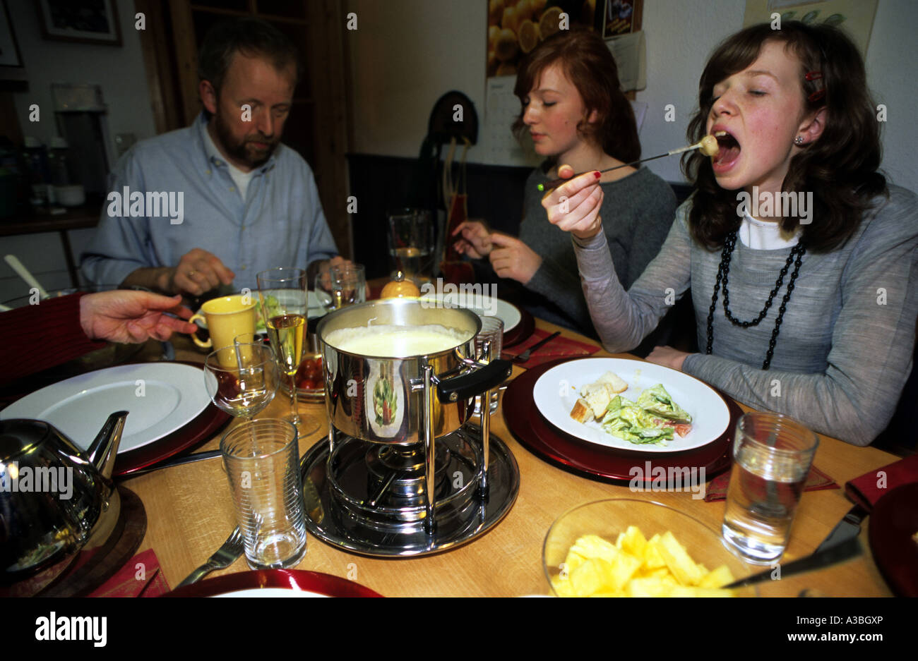 Una famiglia di mangiare la fonduta di formaggio in casa loro a Solingen, Renania settentrionale-Vestfalia (Germania). Foto Stock