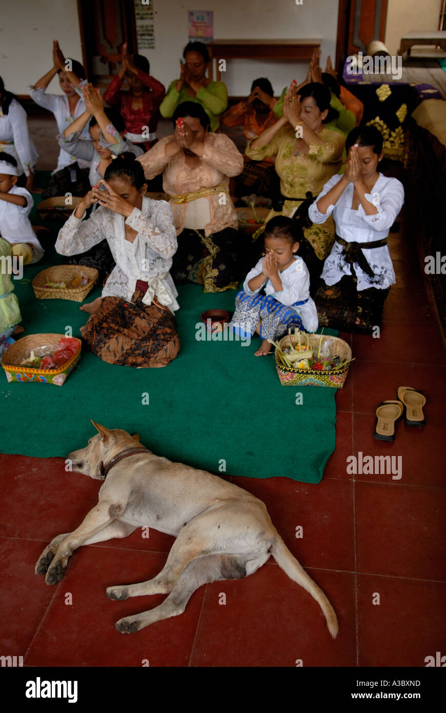 Bali Hindu donne e bambini che pregano insieme con Canang offerte Sang Hyang Widhi Wasa tempio della divinità. Seminyak Bali Indonesia 2006 anni 2000 HOMER SYKES Foto Stock