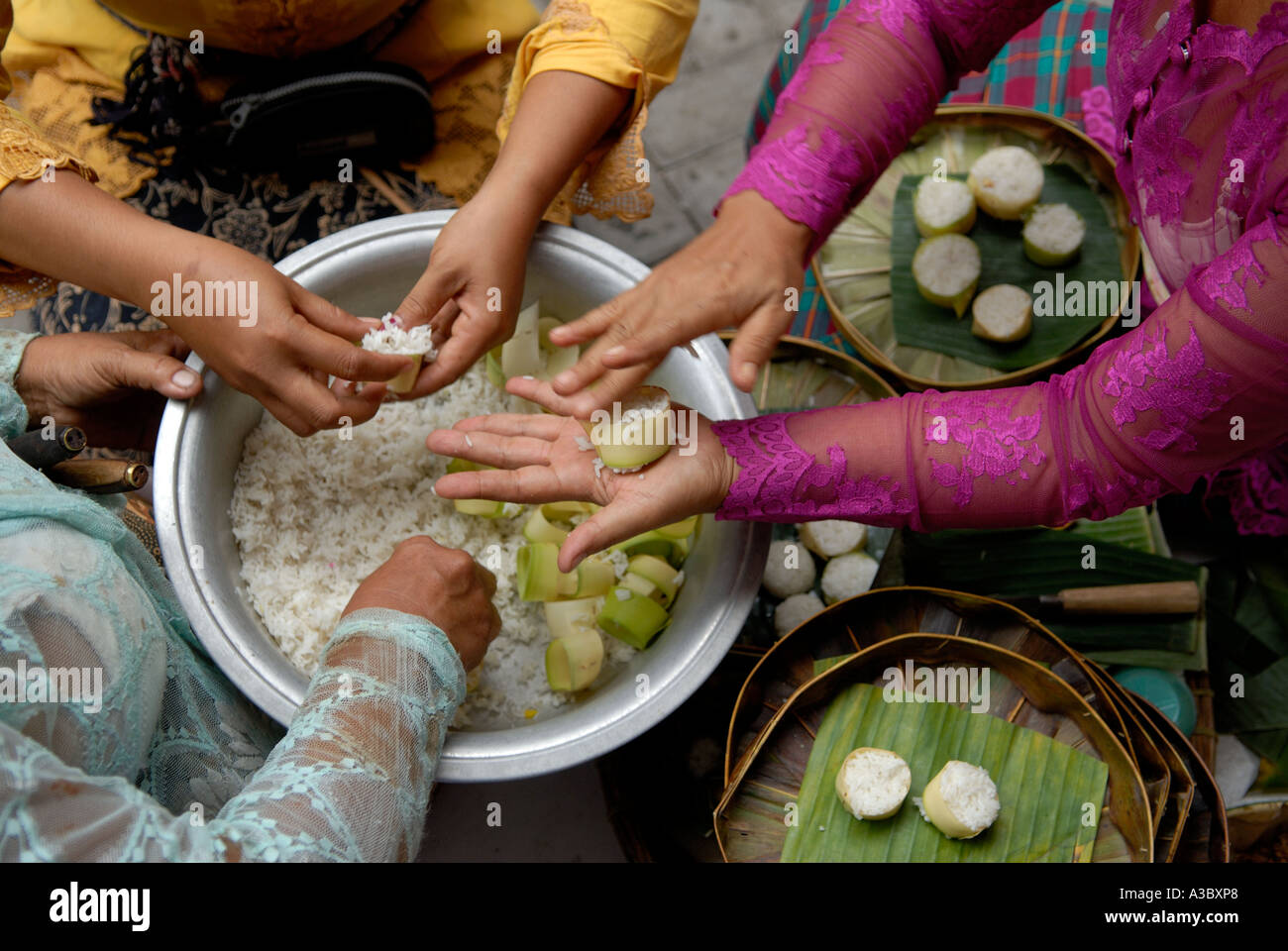 Donne nel tempio di Seminyak, stanno facendo le offerte religiose quotidiane chiamate Canang. Bali Indonesia 2006 anni 2000 HOMER SYKES Foto Stock