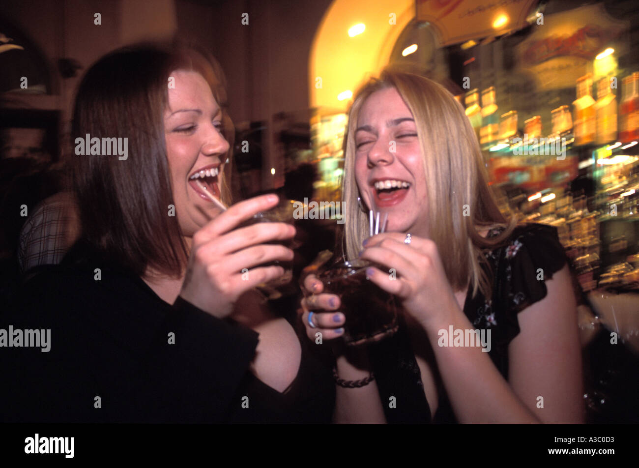 Le giovani donne a bere sulla notte fuori in pub, England, Regno Unito Foto Stock