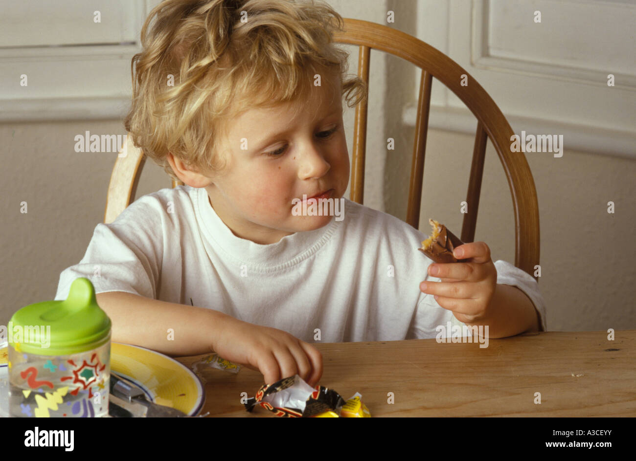 Bambino mangiare un mars bar dopo il suo pasto Foto Stock
