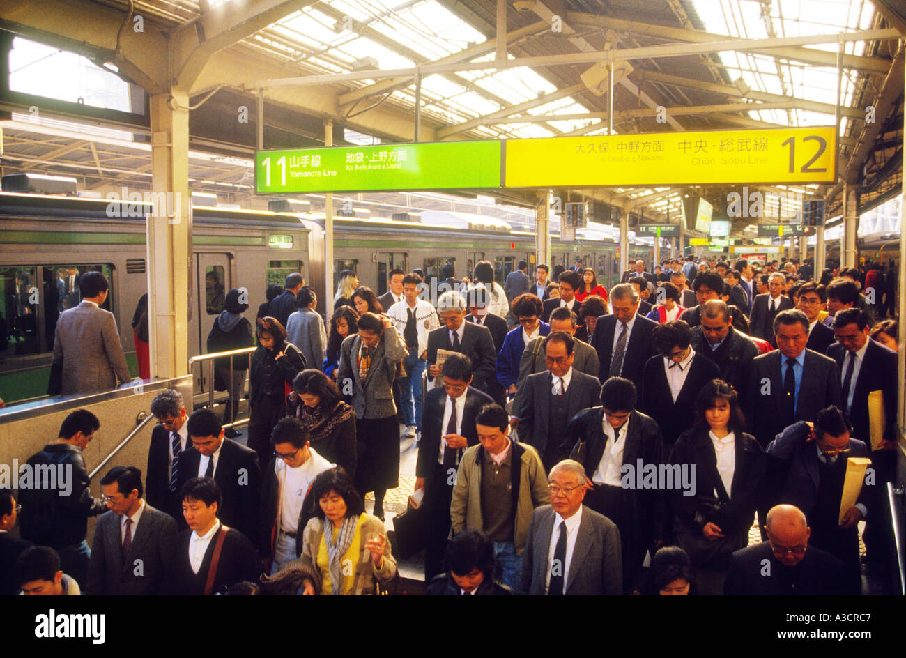 Asia Giappone Tokyo stazione di Shinjuku Rush Hour affollata folla pendolari. Treno spintori spingere il maggior numero possibile di passeggeri in rush Foto Stock