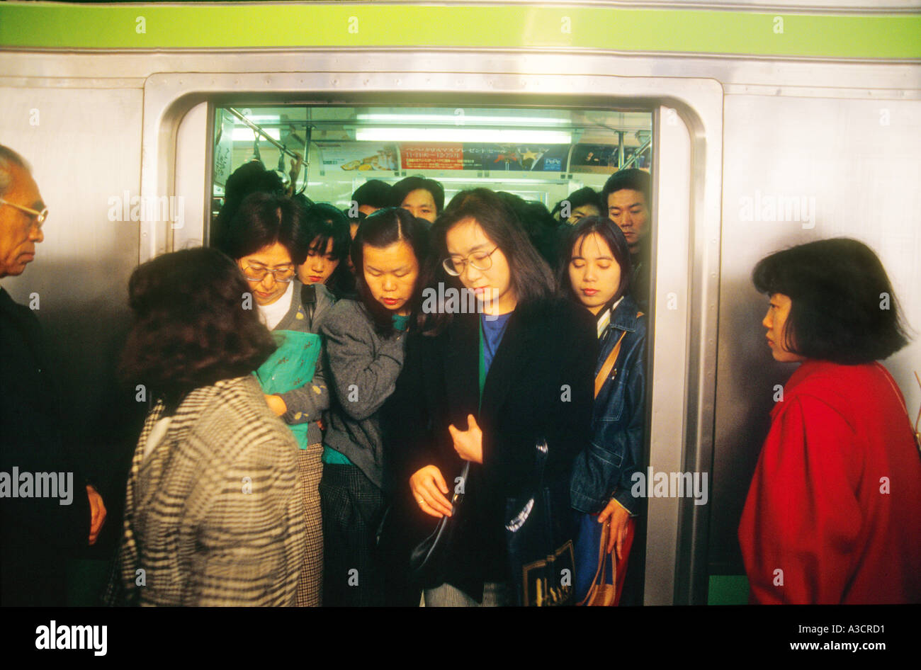 Asia Giappone Tokyo stazione di Shinjuku Rush Hour affollata folla pendolari. Treno spintori spingere il maggior numero possibile di passeggeri in rush Foto Stock