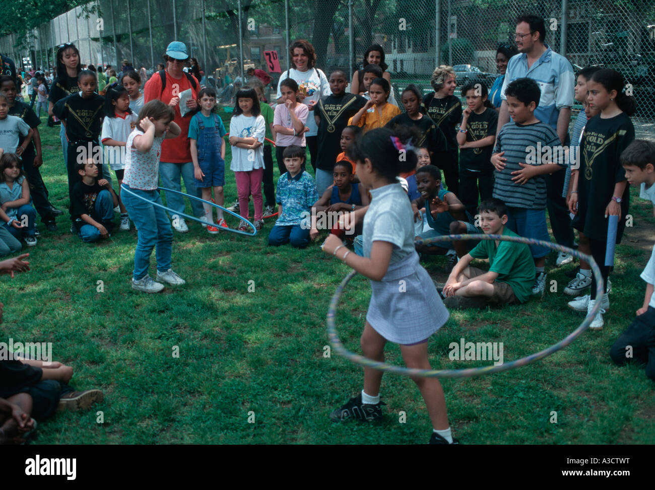 Scuola elementare i bambini partecipano in un hula hoop concorrenza a un campo giornata nel parco di Brooklyn NY Foto Stock