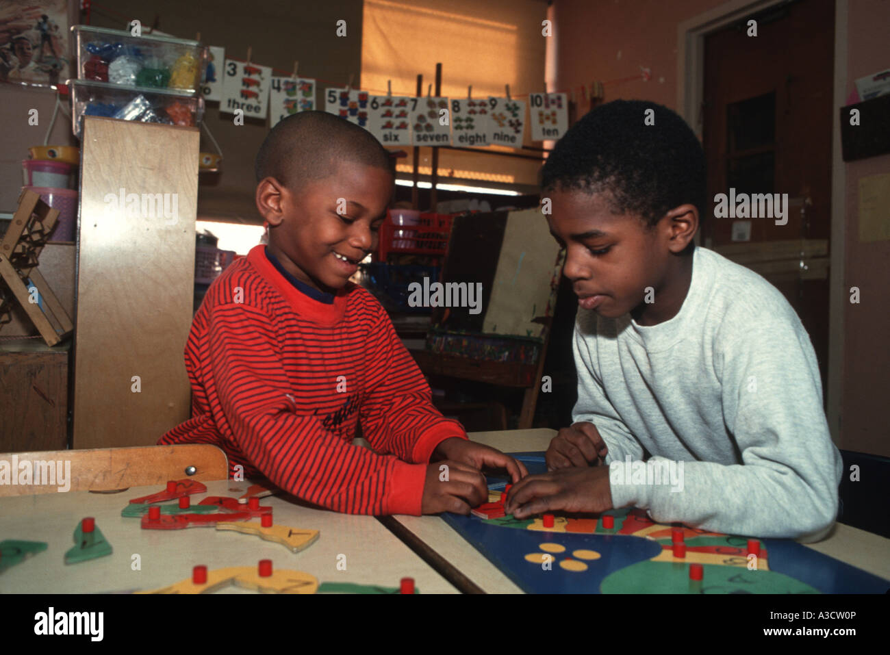 Due gli studenti della scuola elementare a lavorare insieme su un puzzle in Brooklyn New York Foto Stock