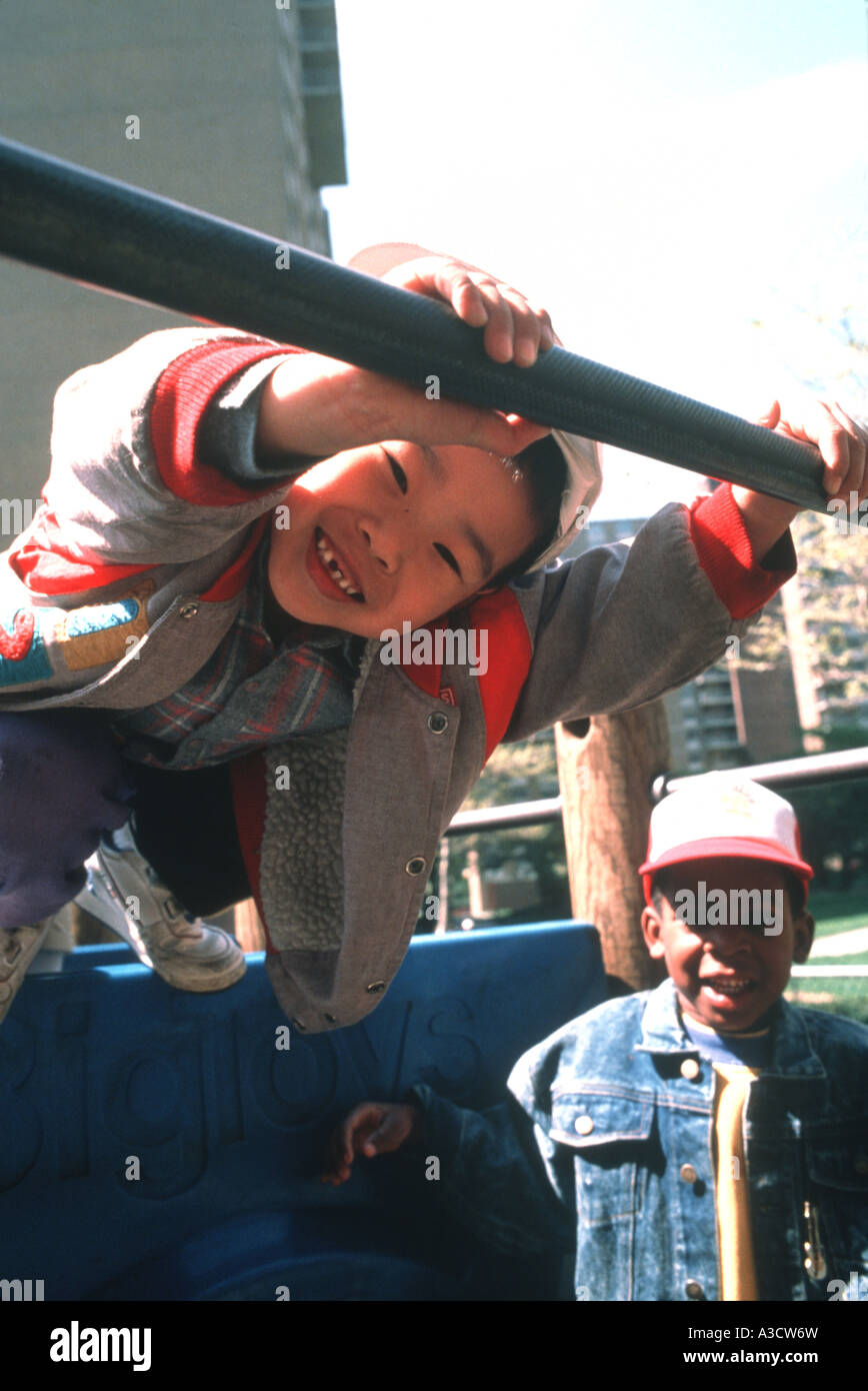 Happy Chinese American Boy sul parco giochi presso la scuola materna a Brooklyn NY Foto Stock