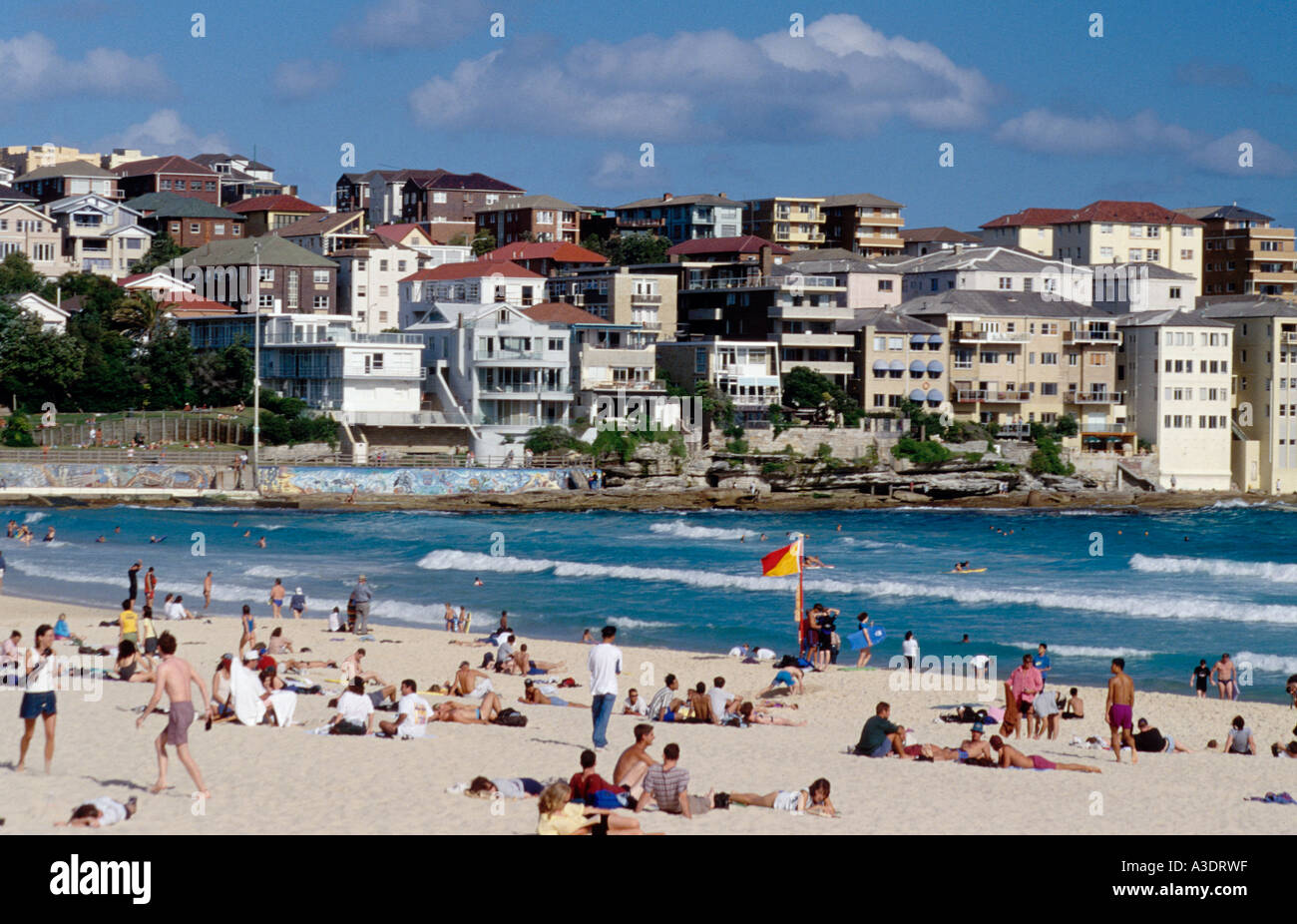 La spiaggia di Bondi, Sydney, Australia, persone sole, case in background Foto Stock