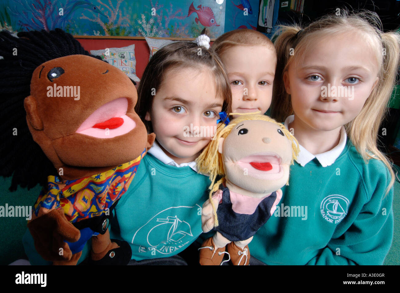 3 tre bambini in uniformi di scuola con fantoccio bambole in aula Foto Stock