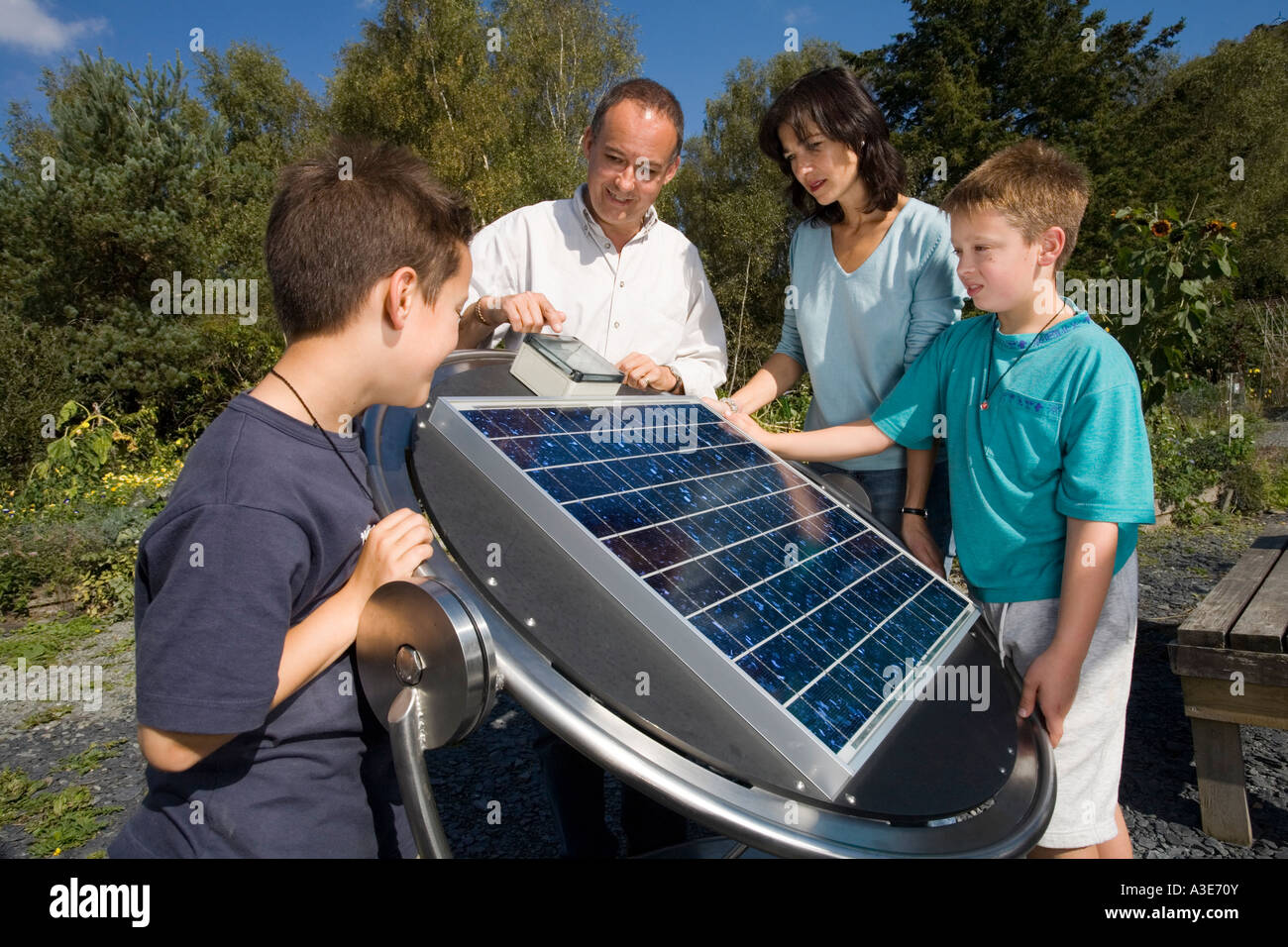 Famiglia con con pannello solare display presso il Centre for Alternative Technology, Machynlleth, Galles Foto Stock