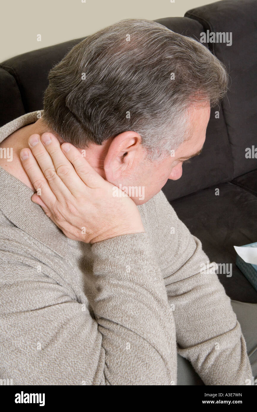 Uomo con dolore tiene il suo collo. Foto Stock