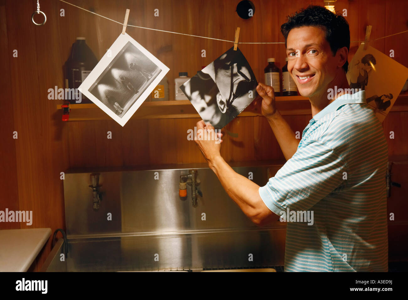 Ritratto di un uomo maturo tenendo le fotografie in una stanza buia Foto Stock