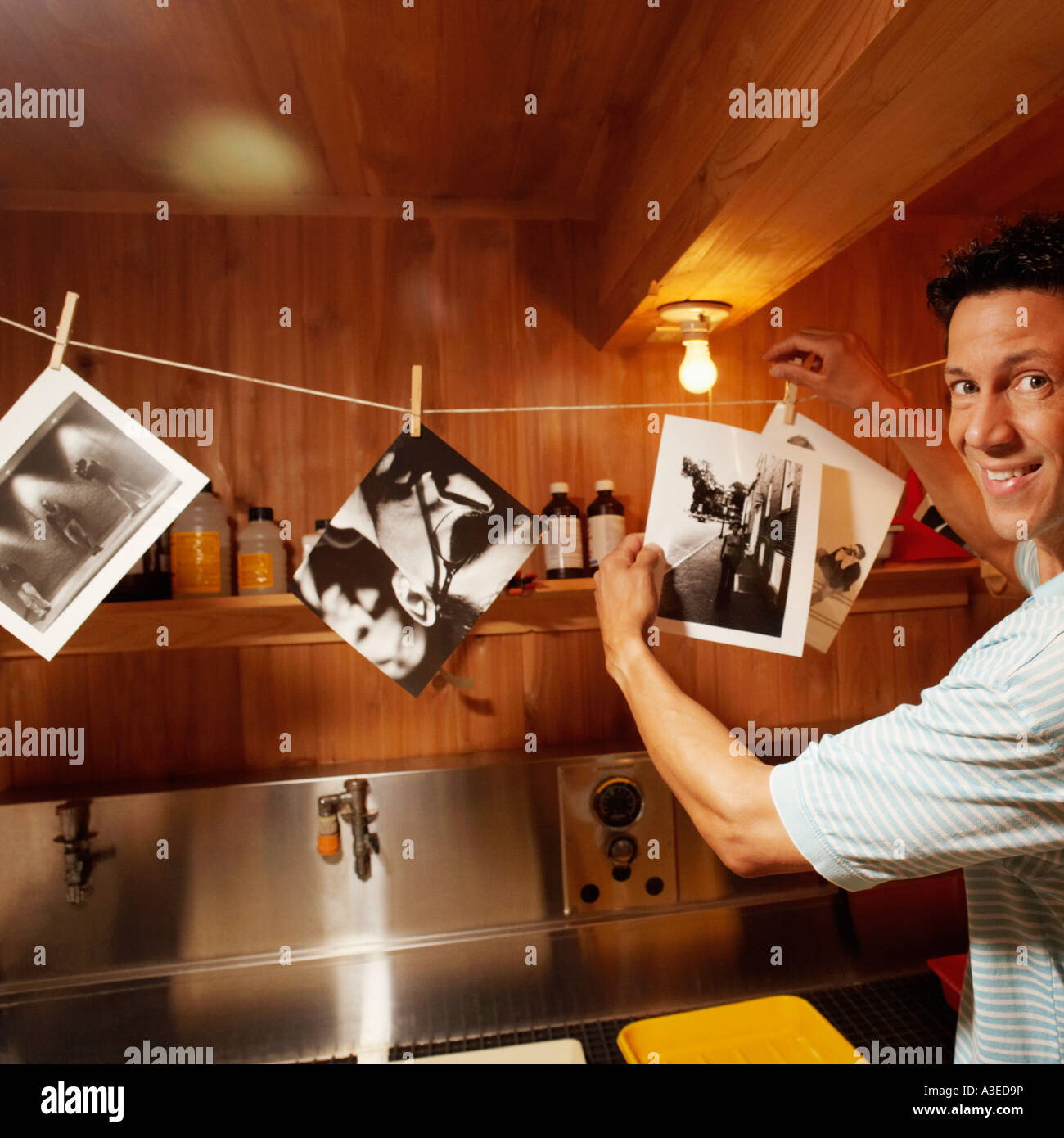 Ritratto di un uomo maturo tenendo le fotografie in una stanza buia Foto Stock
