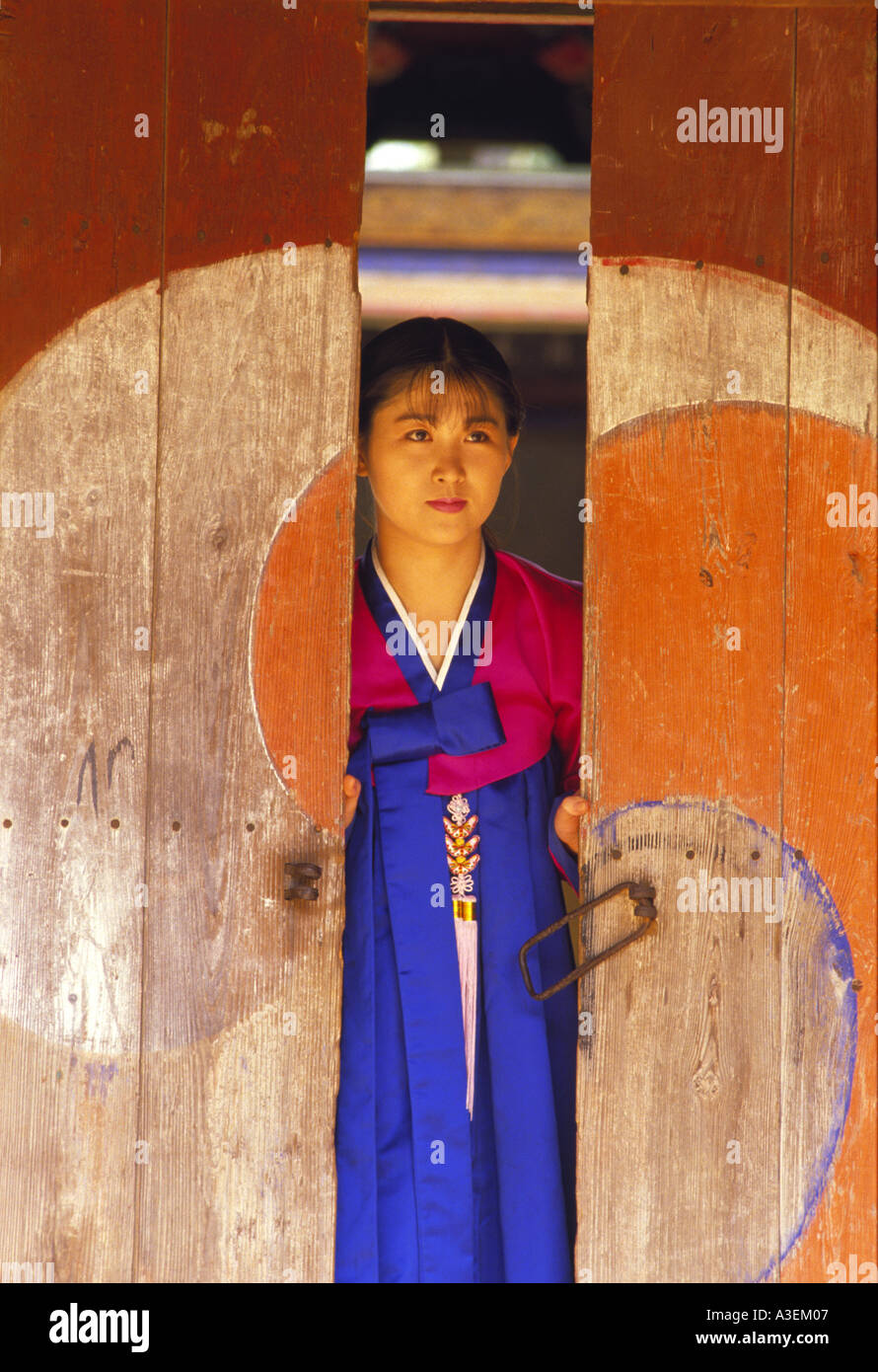 Una giovane donna coreana con costume tradizionale poste accanto a una porta coreano Korean Folk Village Corea del Sud Foto Stock