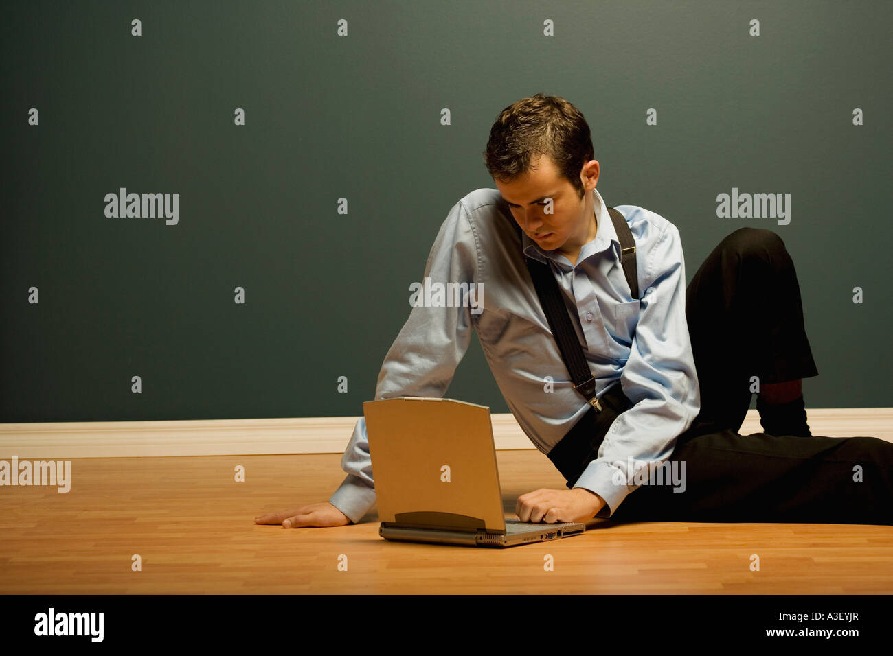Uomo con notebook sul pavimento Foto Stock